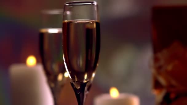 Kieliszki szampana przy świecach obracające się — Wideo stockowe