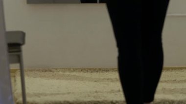 Bir müşterinin bacaklarının üzerinden yukarı doğru eğiliyor.