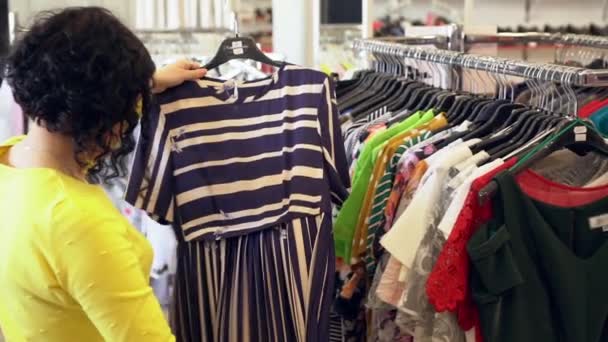 Trendy jonge vrouw winkelen voor kleding — Stockvideo