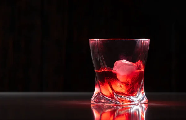 Glass Neat Brandy Rocks Ice Cubes Reflective Surface Dark Background — Stock Photo, Image