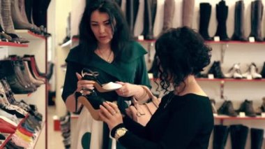 Mağazada moda ayakkabıları seçen bir müşteri