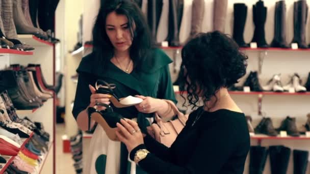 Πελάτης που επιλέγει παπούτσια μόδας σε ένα κατάστημα — Αρχείο Βίντεο