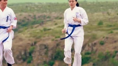 Giyinik kızlar ve dövüş sanatları kemerleri çalışıyor.