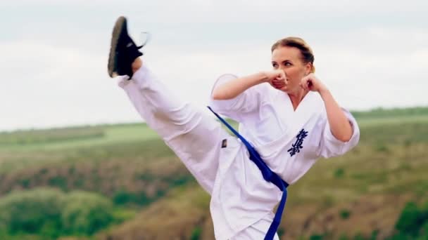 Mujer joven practicando kick boxing al aire libre — Vídeo de stock