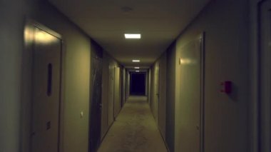 Dar, loş bir geçitte hızla yürüyorum.