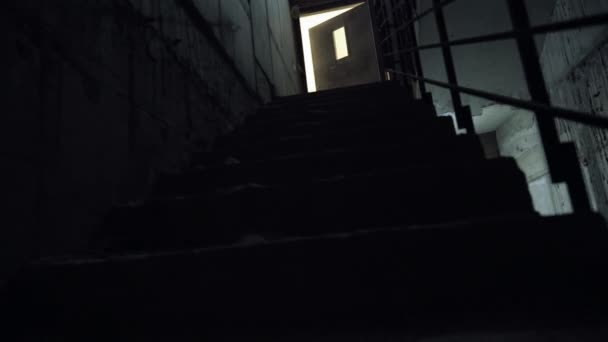 Escalade d'un escalier intérieur sombre — Video