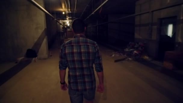 Man walking away from the camera in a basement — Stock Video