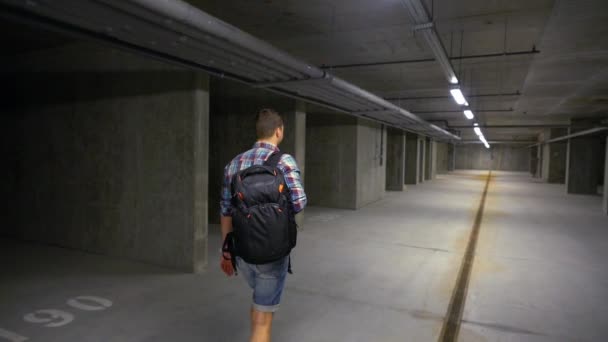 Joven caminando por un sótano industrial — Vídeos de Stock