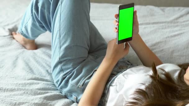 Uitzoomen op een jonge vrouw met een mobiele telefoon — Stockvideo