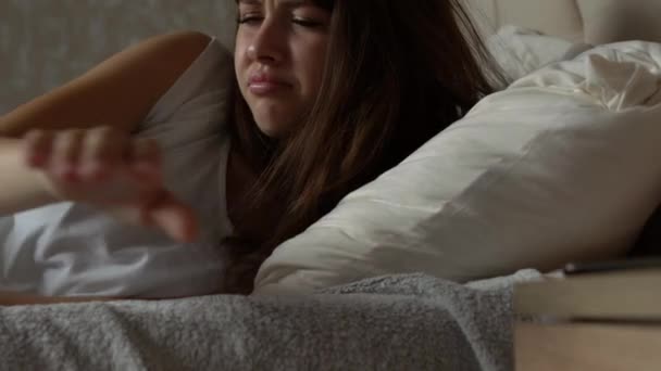 Tired young woman waking up to check her mobile — Stock Video