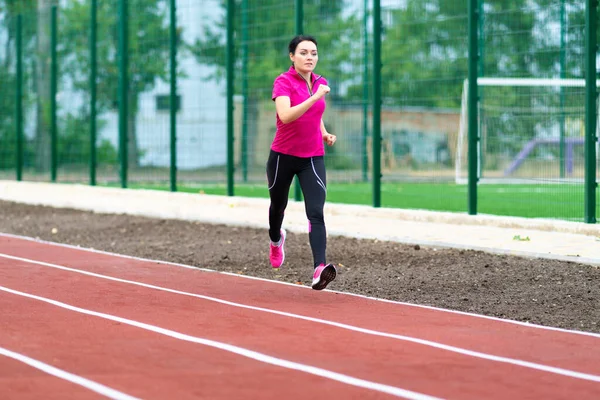 年轻的女赛跑选手在体育场的赛马场上接受健康 健康或积极的生活方式概念的训练 并有版权 — 图库照片