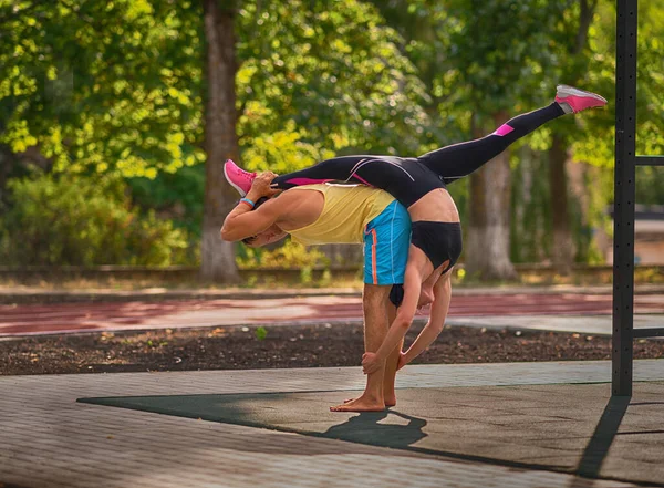 Pareja Joven Realizando Gimnasia Acrobática Con Joven Haciendo Las Divisiones — Foto de Stock