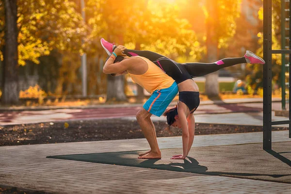 Mladý Pár Dělá Akrobatickou Gymnastiku Venku Podsvícený Teplem Ranního Slunce — Stock fotografie