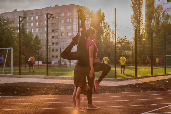 Twee Jonge Vrouwen Die Buiten Acrobatische Yoga Beoefenen Een Sportbaan — Stockfoto