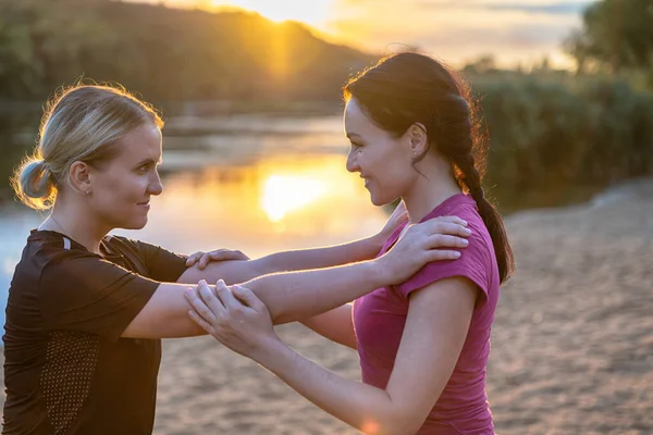 Twee Jonge Vrouwen Omhelzen Bij Zonsondergang Een Zandstrand Met Reflectie — Stockfoto