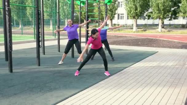 Tres mujer joven flexible haciendo tramos de giro — Vídeos de Stock