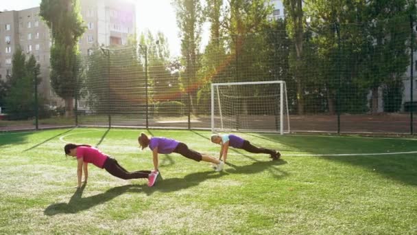 Tres amigas o compañeras de equipo haciendo ejercicio — Vídeos de Stock