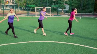 Üç atletik genç bayan atlama egzersizleri yapıyor.