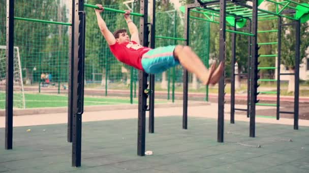 젊은 체조 선수가 바에서 뛰어내리는 모습 — 비디오