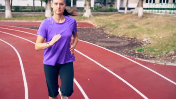 Ajuste jovem correndo em uma pista de esportes — Vídeo de Stock