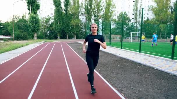 Ajuste muscular jovem correndo em uma pista — Vídeo de Stock