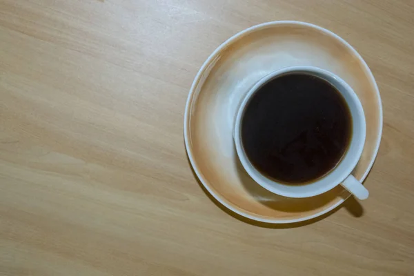 a Cup of coffee on a light wooden table.