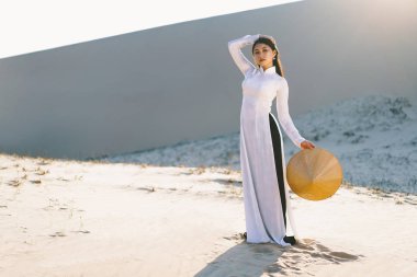 Vietnam kültürüne sahip güzel Vietnamlı kadın geleneksel elbisesi beyaz bir kumun üzerinde duruyor Mui ne, Ho Chi Minh Şehri Vietnam