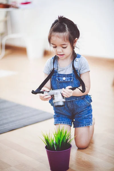 小さな女の子の保持しているカメラ — ストック写真