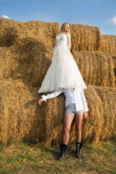 Pengantin wanita berdiri di atas mempelai pria dia berada di celana dalamnya di bawah gaun pengantin wanita — Stok Foto