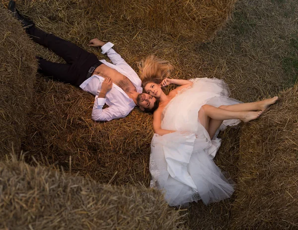 新郎抚摸新娘的头, 而她躺在干草上 图库图片