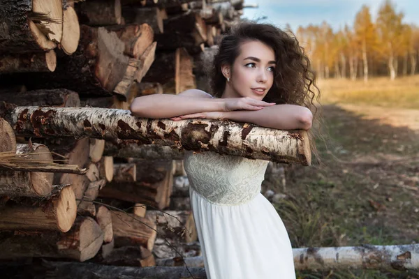 A young adult girl clapped on a birch log — Stock Photo, Image