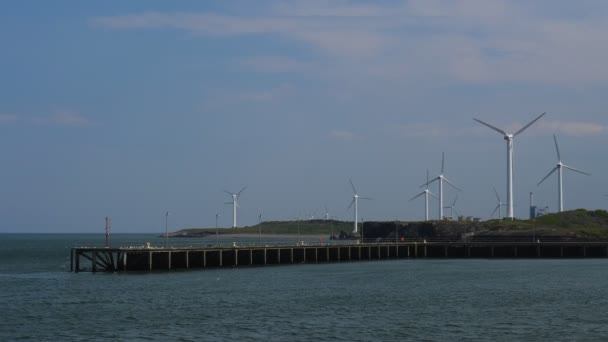 风电场与风力涡轮机和工业建筑坐落在爱尔兰海岸在英格兰的西北部 码头在前景 — 图库视频影像