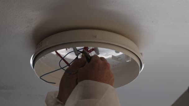 Close Up Of Hands Of An Electrician Connecting Wires Of Ceiling Light
