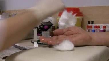 Kadın hemşire tıbbi laboratuvar parmak erkek hastanın kan alarak kapatın. Arka planda dönen şişeleri kan tüpleri 