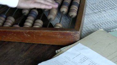 Kapalı giderleri veya evrak ile ahşap masa üzerinde abacus kullanarak kar sayım muhasebeci gösterilen sahne
