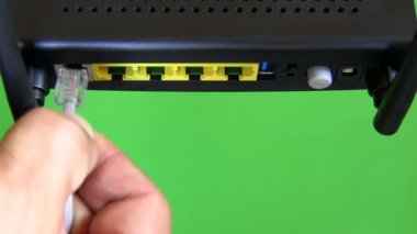 Yeşil arka plan üzerinde izole bilgisayar internet yönlendirici ve modem açılan, yakın çekim. Kabloları içinde tanıttığım ve cihazın açılıp el.