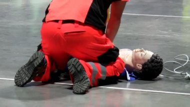 Kırmızı sağlık görevlisi Tekdüzen göğüs Cpr kukla katta, arka görüş Tarih sıkıştırmada yerdeki adam