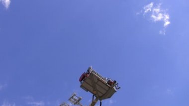 Teleskopik itfaiye anteni merdiven, platform bu insanlarla topluyor. Mavi gökyüzü arka plan