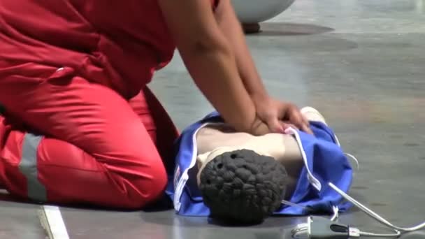 穿红色制服的妇女进行心肺复苏 在地板上的人体模型 Cpr 侧面观察 — 图库视频影像