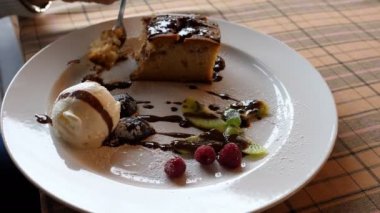 Plaka dondurma ve pasta tatlı masa örtüsü ile kaplı tablo ile kapatın. Kadın eli yiyecek çatal, sığ derinlik-in tarla kullanarak parçaları toplama