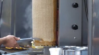 Şef take-away dükkanı veya eve servis restoran döner donner kebap et döner üzerinden elektrikli bıçak kullanarak tükürmek Dilimleme