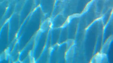 Su yüzeyine oynayan güneş ışığı. Dokulu mavi arka plan