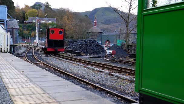 红色和黑色的小蒸汽机停在煤堆上装载一些燃料 — 图库视频影像