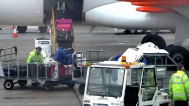 Manchester Airport, Terminal 1, İngiltere, Amerika Birleşik Devletleri - 14 Ekim 2014: at 9:20 de sabah adamın A320 uçak Bagaj atma içinde çalışan takım yükleme Bagaj