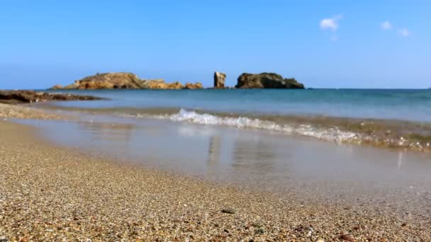 ビーチ ギリシャのクレタ島で地平線上の岩の美しい風景です 砂のローアングル ショット水の端で砂利し 地中海の青 — ストック動画