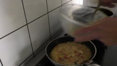 Profesyonel Yunan kızartma tavası dökme yumurta karışımı pişirmek ve yemek, elinde yakın çekim; pişmiş ve omlet veya omlet tablo, el kamera tabakta yemek hazır