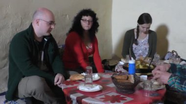 Fas Berberi ev Avrupalı turistlerin içinde akşam yemeği için tavuk tajine yaşıyorsanız. Sebze ve tavuk etinden oluşan yemeğin yakın çekim. Bir odada 2 klip
