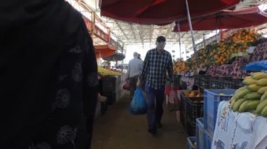 Agadir, Fas - Mart, 2016: kamera yerel geçen çanta taşıyan insanlar üretmek piyasa meyve ve sebze tezgahları