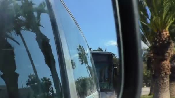 公共汽车边镜子看法驾驶在摩洛哥城市 棕榈树和蓝天 — 图库视频影像