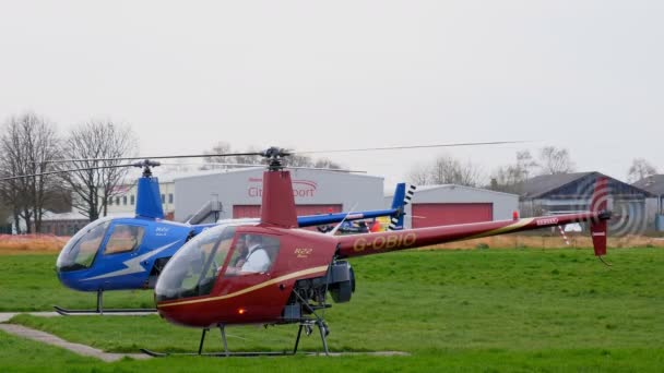 大きいマンチェスター イギリス イギリス 2019 小型ヘリコプターは回転翼と地面には飛行教官に話している小屋の中の研修生 — ストック動画